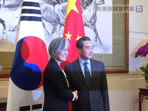 韩国外长快步上前与王毅握手，外交舞台上的友好瞬间